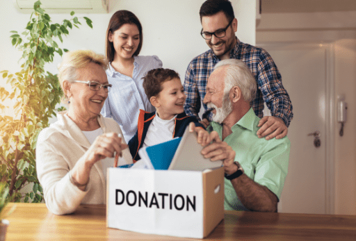 group of family sitting around a donation box
